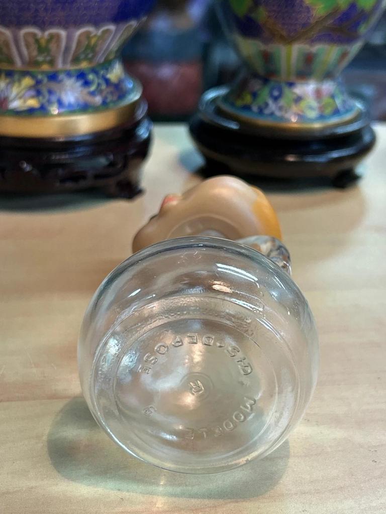 Petite bouteille en verre avec tête de femme