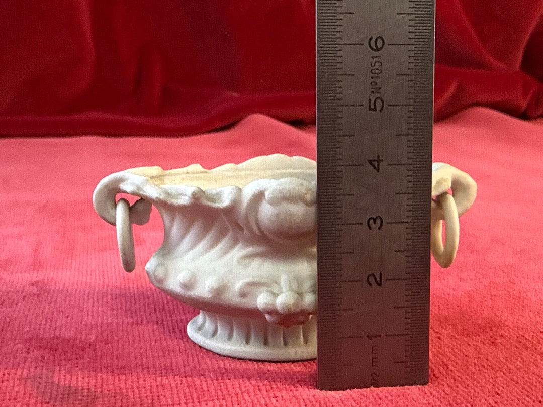 Cache-pot ovale en céramique blanche patinée, anneaux et décor en relief