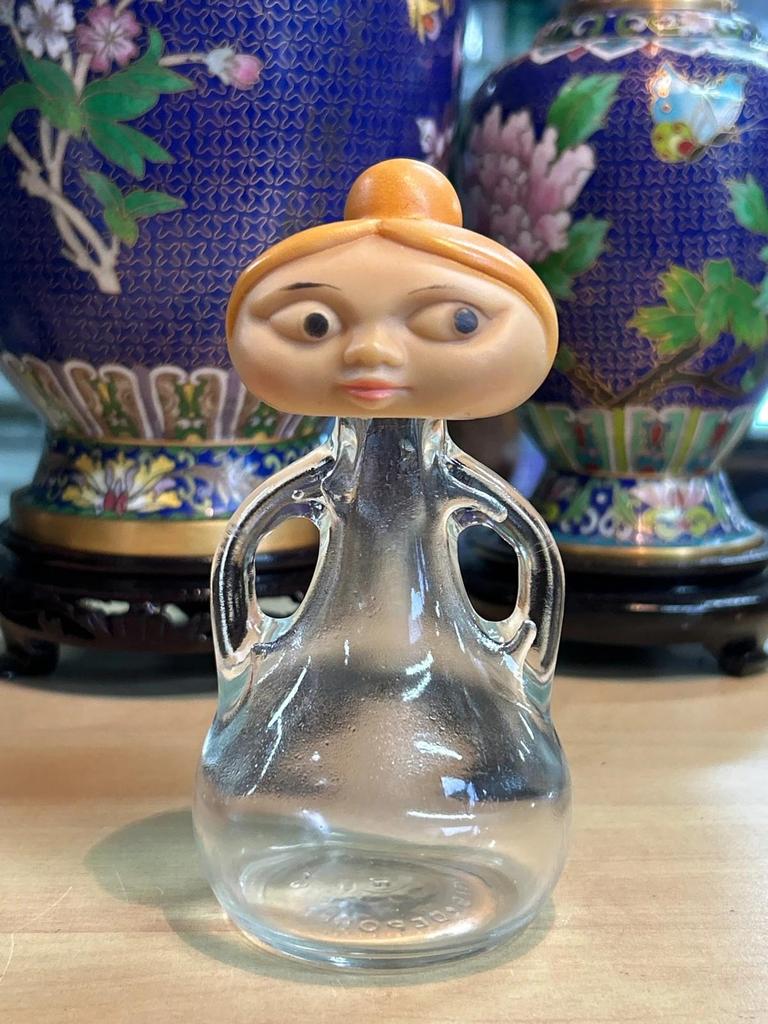 Petite bouteille en verre avec tête de femme