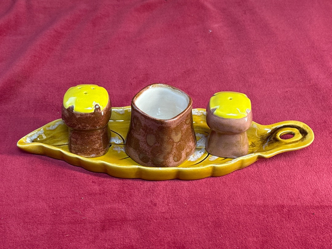 Service à condiments en céramique jaune et brune sur plateau feuille