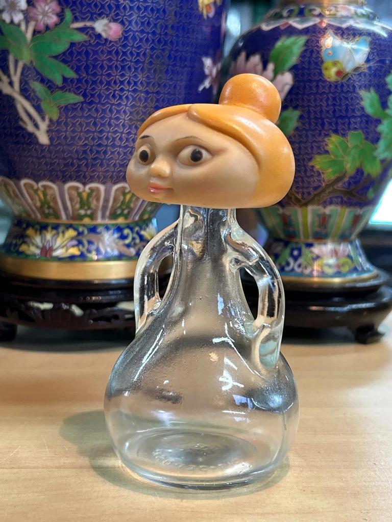 Petite bouteille en verre avec tête de femme