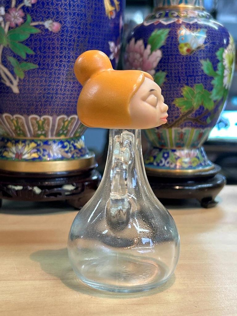 Petite bouteille en verre avec tête de femme